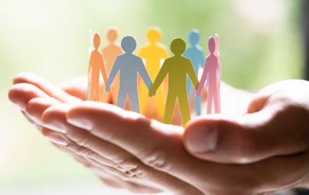 A person holding a paper cutout of people, promoting Diversity, Equity, Inclusion, and Accessibility.